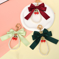 Porte-clés créatif polyvalent avec nœud papillon et petites perles, pendentif pour sac de téléphone portable pour femme