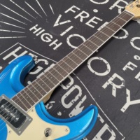 Guitare Blue Deluxe Mark II Ventura Johney Ramne Mosrte, manche en palissandre, micros HH, barre vibrato Tun-A-Matic, 6 cordes, acajou