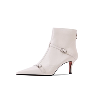 Sepatu bot wanita dengan ujung runcing, hak tipis, penutup ritsleting, dan hiasan gesper