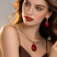 Ensemble de bijoux quatre pièces en résine couleur unie, comprenant un pendentif goutte d'eau, un collier ras-du-cou serpent lisse, des boucles d'oreilles, une bague et un bracelet