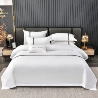 Ensemble de draps de lit de style hôtelier en coton blanc avec bordure à rayures jacquard grises, broderie personnalisée du logo de la marque, housse de couette