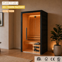 Sauna intérieur PLOUTARA avec chauffage en pierre, cadre noir, intérieur en bois clair, banc large et éclairage en bande sur le dessus
