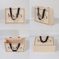 Sac de shopping en papier ivoire de luxe avec logo personnalisé, poignée en ruban noir, emballage cadeau pour boutique, vente en gros