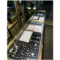 Boutique de bijoux de style industriel, aménagement complet sur mesure, îlot central, vitrine, armoires murales avec escalier en colimaçon