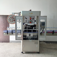Machine d'étiquetage automatique linéaire pour bouteilles avec tunnel de rétraction à la vapeur
