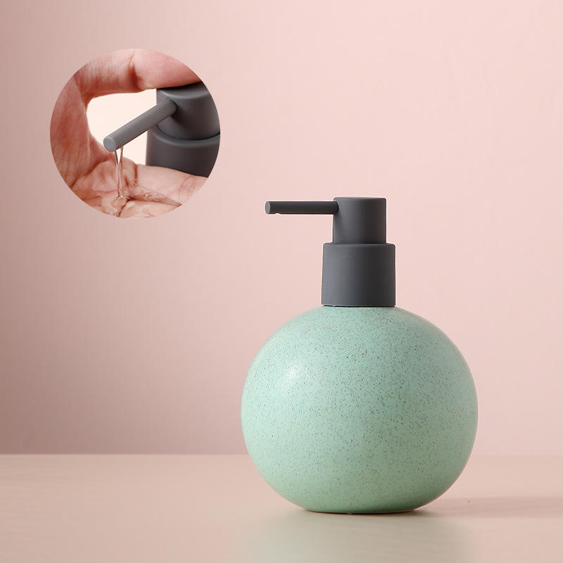 Lotion - grand flacon rose et vert - avec pompe distributrice orientée vers le bas.