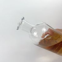 Bouteille d'alcool ronde en verre à bouche plate avec gaufrage gravé