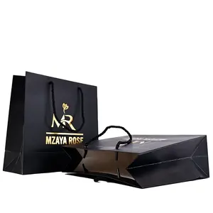 حقيبة تسوق ورقية مميزة مطبوعة مخصصة بشعار العلامة التجارية سوداء اللون للملابس تُباع بالتجزئة كهدية مع مقابض شريطية
