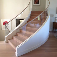 Escalier intérieur courbé artistique de luxe en promotion avec éclairage LED, marches en marbre et bois, et garde-corps en verre pour villa