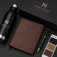 Ensemble cadeau d'entreprise personnalisé avec logo, comprenant une bouteille gravée, un carnet en cuir, un stylo en métal et un coffret cadeau haut de gamme