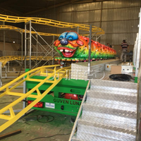 Manège pliable géant Caterpillar vert sur remorque, équipement d'amusement portable, idéal pour les fêtes foraines nomades.