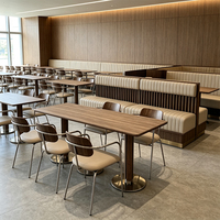 Mobilier de salon de luxe moderne : banquette incurvée en cuir beige, tables à manger rondes en noyer et chaises à pieds chromés pour hôtel et bar