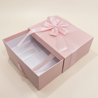 Stabile Geschenkbox im Schubladenstil mit Schleifenband, handgefertigt von einem Architekturstudio, raffiniertes rosa Etui für Bekleidung.