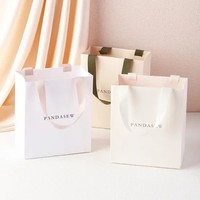 Sac en papier blanc de luxe personnalisé avec logo en feuille d'or pour le shopping, les cadeaux, les vêtements, les robes, l'emballage de vêtements avec poignée