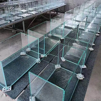 Grand aquarium en verre avec meuble en aluminium, système de débordement et filtre externe.