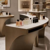 Meuble de présentation cosmétique incurvé moderne sur mesure, comptoir îlot en métal pour parfums, vitrine murale LED pour magasin de beauté de luxe