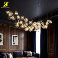 Lustre LED artistique en boules de verre - Suspension cascade dorée pour hall d'hôtel et atrium