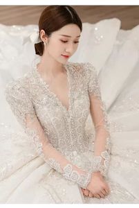 NDB10443 فستان زفاف فاخر وعصري للعروس، تصميم تنورة بفتحة رقبة على شكل V وأكمام طويلة وظهر مكشوف، مزين بالخرز والدانتيل والكشكشة والتطريزات - Product Image 3