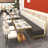 Banquette de restaurant avec cadre doré, cloison de séparation en verre intégrée, sièges modernes en cuir blanc, idéale pour centre commercial et hôtel