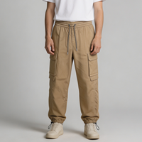 Celana Jogger Cargo Pria Warna Tan Khaki, Model Relaxed Tapered, Pinggang Elastis dengan Tali Serut, Kantong Bellows, Kantong Welt, Kantong Bungee, Grosir OEM