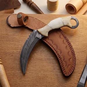 Couteau de chasse artisanal en acier Damas avec lame à pointe dentelée et manche en os, dans un étui en cuir - Product Image 1