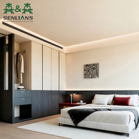 Armoire de chambre moderne sur mesure avec portes blanches sans poignées, placards en noyer foncé, tringle de suspension ouverte et tiroirs latéraux