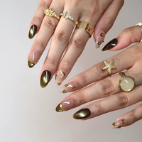 Ongles press-on rétro vert olive, forme amande, effet œil-de-chat, base nude, French manucure, petites fleurs dorées, chaîne de perles dorées, ongles élégants