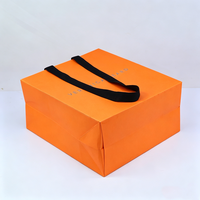 Sac en papier de luxe grande capacité pour vêtements et snacks, avec poignée en ruban orange personnalisée et votre propre logo