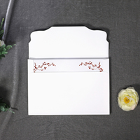 Porte-invitation haut de gamme blanc à couverture rigide avec logo floral estampé or rouge, fente intérieure pour RSVP et enveloppe assortie pour mariages et événements.