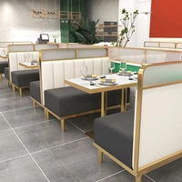 Banquette de restaurant confortable et légère en cuir gris à dossier haut, base de table basse dorée et chaise de restaurant blanche