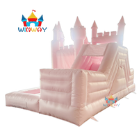 Château gonflable rose sur le thème des princesses avec piscine à balles, aire de jeux extérieure pour enfants.