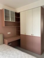 Armoire d'angle moderne avec bureau, portes vitrées, étagères ouvertes et tiroirs en bois brun pour chambre à coucher