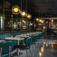 Ensemble de meubles de restaurant, café et bar moderne, tables à manger avec base en métal, sièges en cuir vert et canapé en cuir incurvé