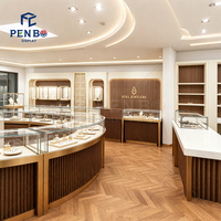 Comptoir d'exposition de bijoux incurvé sur mesure, vitrine en verre avec cadre doré de luxe et éclairage LED pour l'aménagement intérieur d'une bijouterie