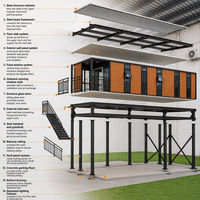 Maison conteneur surélevée à deux étages avec garage, finition bois laminé, structure en acier noir, terrasse vitrée du sol au plafond