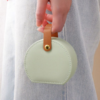 Mini boîte à bijoux ronde en cuir avec poignée, organiseur de voyage portable pour bagues, boucles d'oreilles, colliers