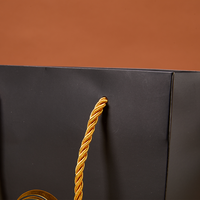 Sac cadeau en papier noir personnalisé avec poignées en ruban pour l'emballage de vêtements, de produits de beauté et de bijoux, vente en gros, haute qualité