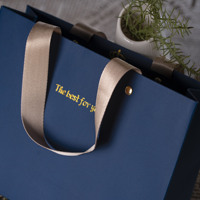 Sac cadeau de luxe en papier couché écologique et recyclable avec option de logo personnalisé estampé à chaud or et poignée en ruban longue pour exposition