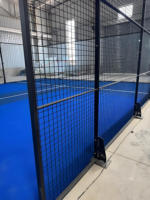 Système de terrain de padel intérieur modulaire avec clôture en verre, gazon bleu et structure métallique pour les centres d'entraînement