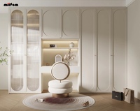 Armoire de chambre personnalisée style crème français avec panneau cintré, vitrine à verre cannelé, table intégrée et rangement encastré, menuiserie de dressing