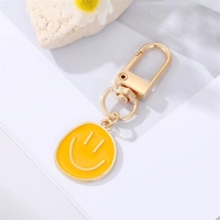 Porte-clés mignon en alliage de zinc jaune bleu noir émaillé avec visage souriant pour femmes