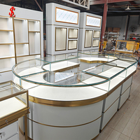 Ensemble de mobilier de boutique de bijoux de luxe sur mesure avec comptoir îlot en verre incurvé, armoires murales rétroéclairées par LED et étagères de présentation