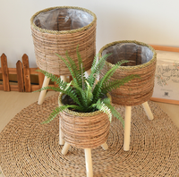 Panier à plantes en jonc de mer tressé style bohème avec support en bois à 3 pieds, doublure en plastique imperméable, décoration intérieure, pot à fleurs, porte-plantes