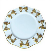 Assiettes de présentation en or blanc avec nœud papillon, bord ondulé et décor en relief, pour la mise en table de banquets de mariage