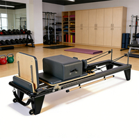 Reformer Pilates à cadre noir avec barre de pieds en bois, longue boîte et poulie réglable pour l'entraînement à domicile et en studio