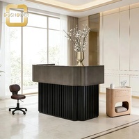 Bureau d'accueil moderne haut de gamme avec base verticale cannelée, comptoir d'accueil élégant noir pour hôtel de luxe, bureau d'accueil de salon.