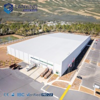 Atelier en structure métallique préfabriquée avec portes à enroulement automatiques et plancher en béton à haute capacité de charge