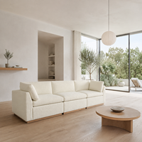 Canapé modulaire 3 places en tissu bouclé avec coussins crème et dossier bas, sectionnel avec base en bois pour salon