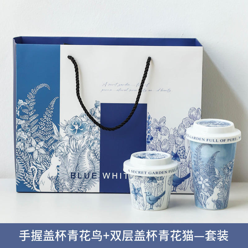 Chat de double couche + main tenant la boîte-cadeau d'oiseau