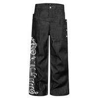 Jean déstructuré à taille asymétrique et boutonnage, avec broderie lourde de notes de musique sur portes-staves, coupe ample et fluide, pantalon long droit